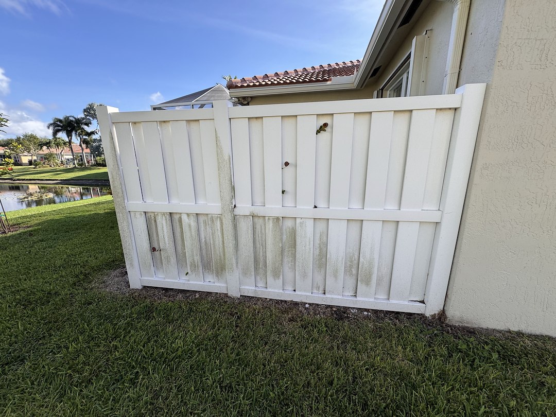 Professional pressure washing of gutters, lanai, vinyl fence and pavers for residential home in Boynton Beach FL 33436